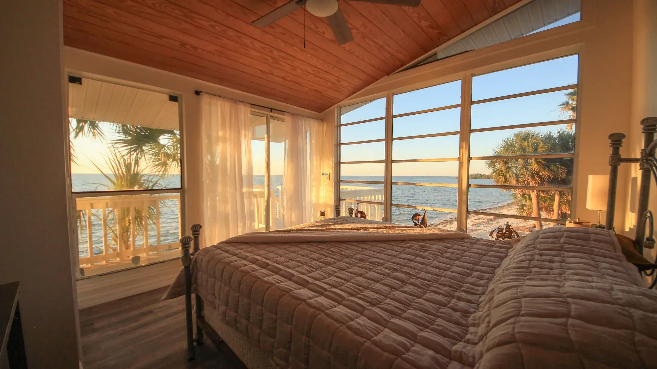Primary bedroom with broad Gulf views and sliding doors toward the porch.